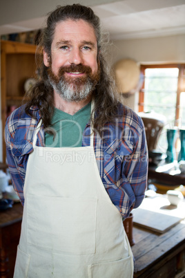 Portrait of male potter standing in pottery workshop