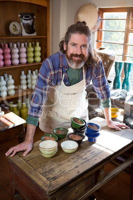 Portrait of male potter standing at table