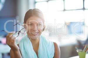 Business executive holding spectacles in office