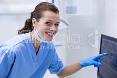 Portrait of dental assistant examining an x-ray on the monitor