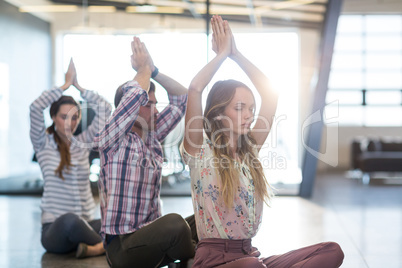 Business people performing yoga on floor