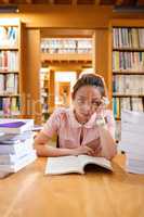 Tensed young woman studying in library