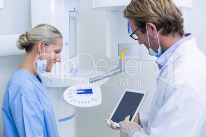 Dentist and dental assistant working on digital tablet