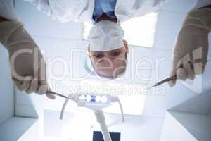 Female dentist holding dental tools