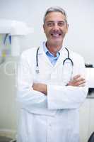 Portrait of dentist standing with arms crossed