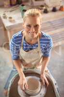 Beautiful female potter making pot