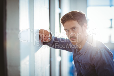 Tired businessman leaning on wall