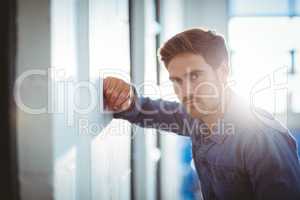 Tired businessman leaning on wall