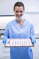 Dental assistant holding tray with equipment