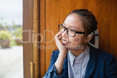 Thoughtful young woman looking through window