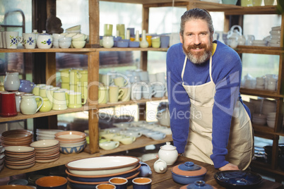 Portrait of male potter standing at table