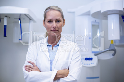 Portrait of female dentist standing with arms crossed