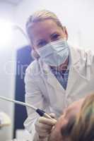 Dentist examining a patient with tool