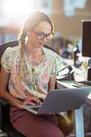 Woman sitting on chair and using laptop