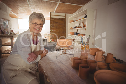 Portrait of female potter sitting at table