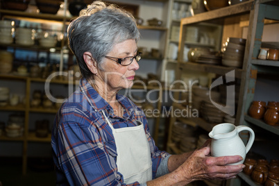 Female potter checking jug