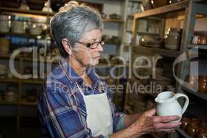 Female potter checking jug