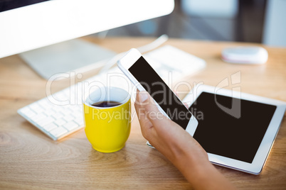 Hand of business executive holding mobile phone