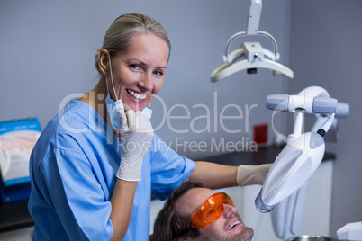 Dental assistant examining young patient mouth