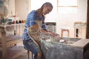 Beautiful female potter making pot