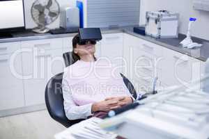 Female patient using virtual reality headset during a dental vis