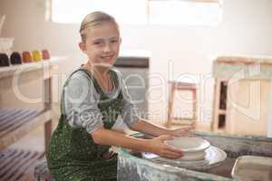 Portrait of happy girl making pot