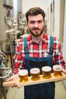 Manufacturer holding beer samples at distillery