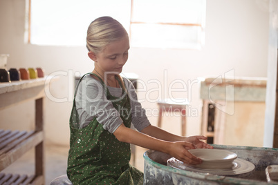 Attentive girl making pot