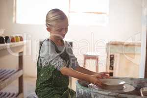 Attentive girl making pot