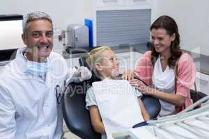Mother and son talking while dentist examining