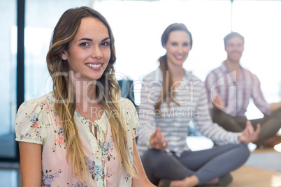 Business people performing yoga in office