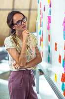 Thoughtful woman looking at sticky notes