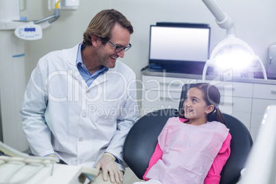 Smiling dentist talking to young patient