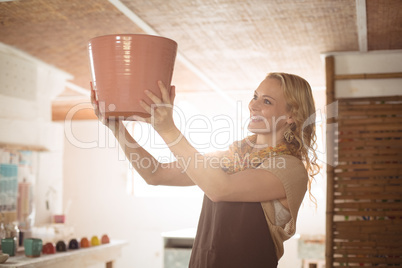 Beautiful female potter checking pot