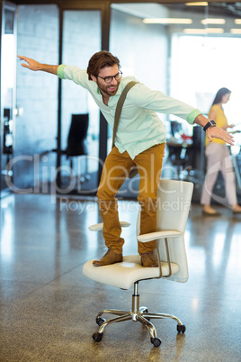 Male business executive standing on chair