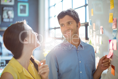 Business executive and co-worker interacting while looking at st