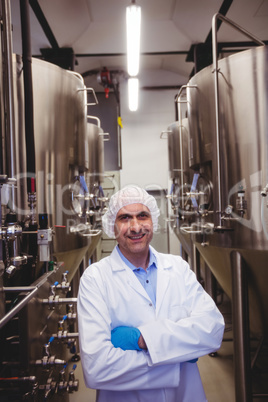 Smiling manufacturer standing at brewery