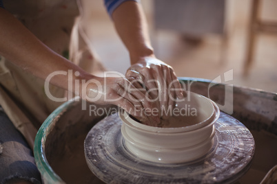 Close-up of female potter making pot