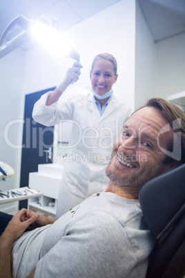 Female dentist and male patient smiling