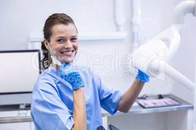 Smiling dental assistant adjusting light Smiling dental assistan