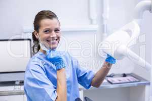 Smiling dental assistant adjusting light Smiling dental assistan