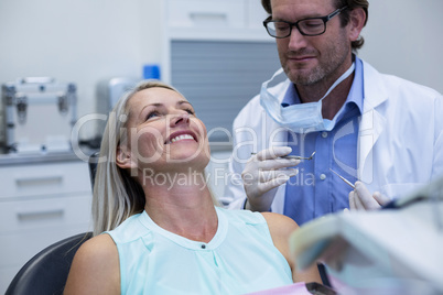 Dentist examining a woman with tools