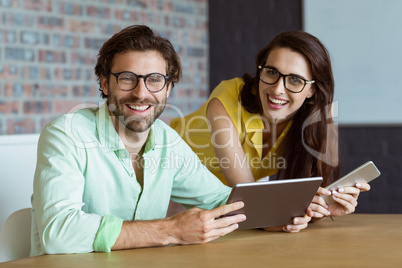 Portrait of business executive and co-worker holding digital tab