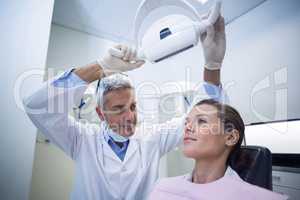 Female dentist adjusting dental lights
