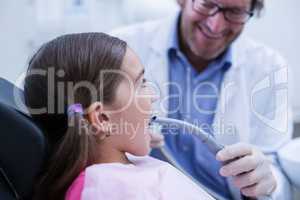 Dentist examining a young patient with tools