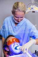 Dentist examining a male patient with dental tool