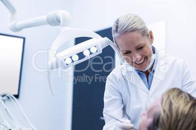 Dentist examining a patient with tools