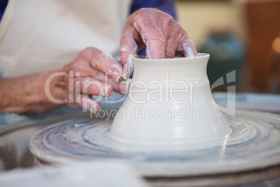 Mid section of potter making pot