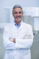 Portrait of dentist standing with arms crossed