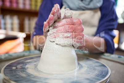 Mid section of female potter making pot